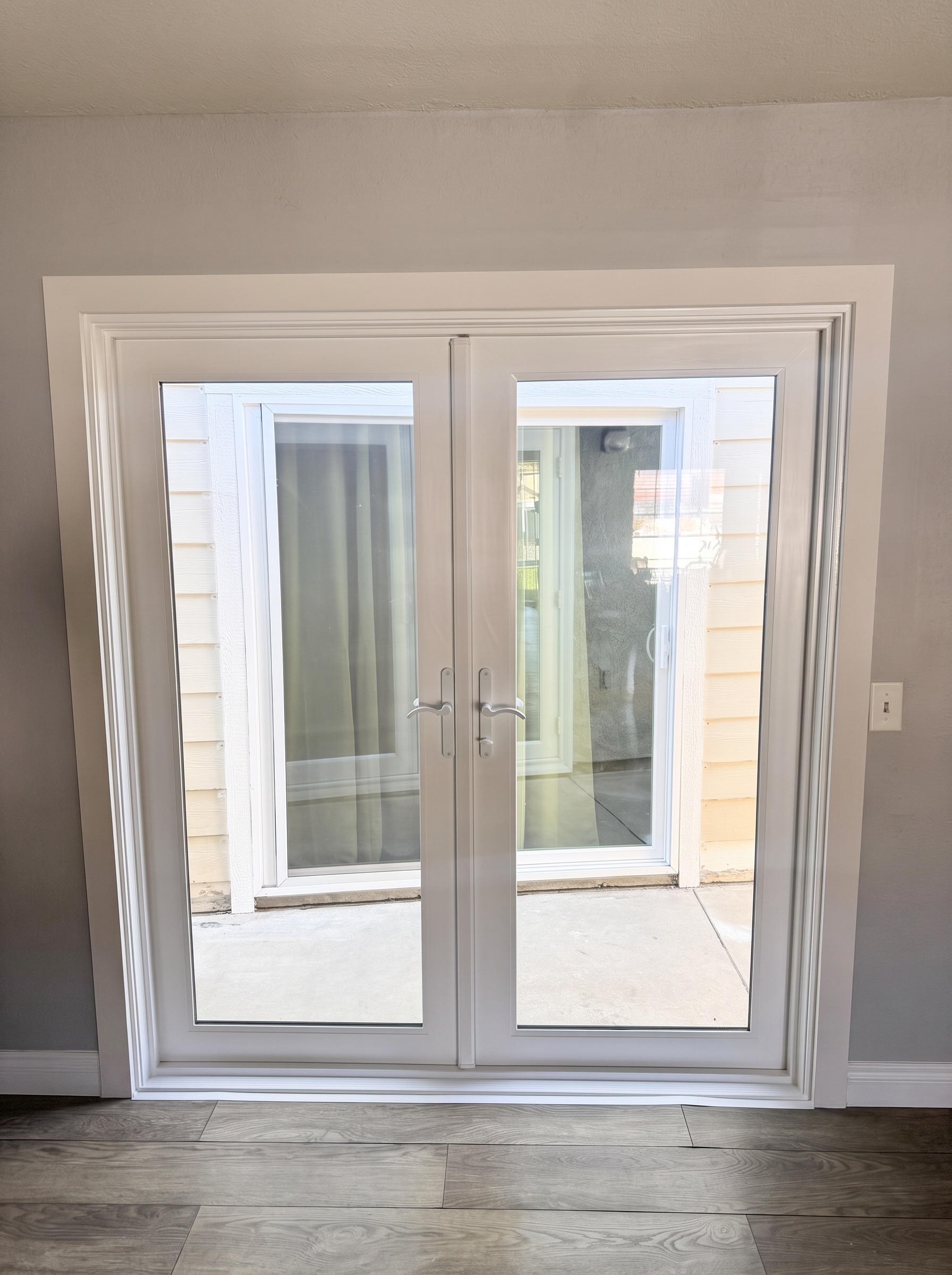 White French doors seen from inside, opening to a patio