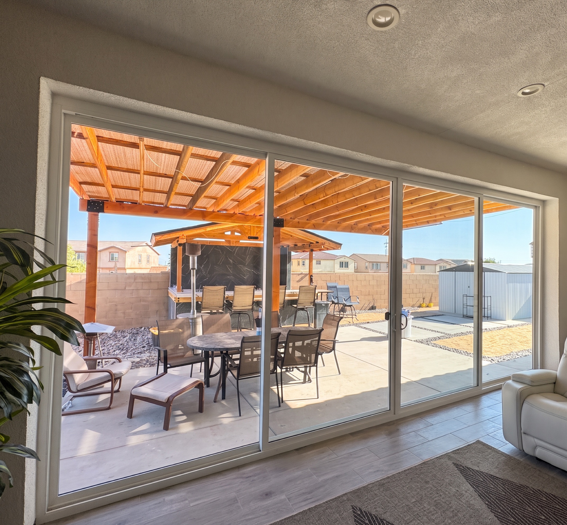 Four-panel sliding patio door opening onto a covered wood pergola patio